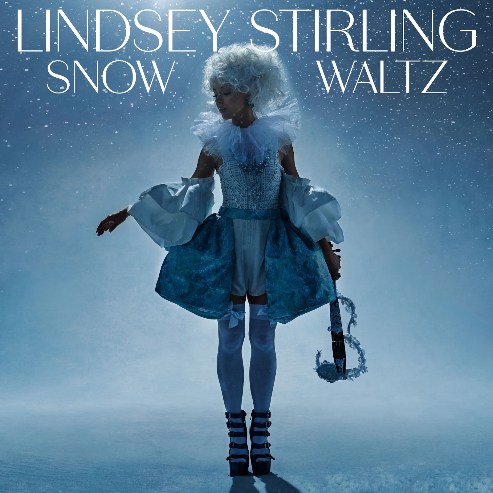 Album cover of Lindsey Stirling's album "Snow Waltz". A woman stands in a snowy expanse holding a violin.